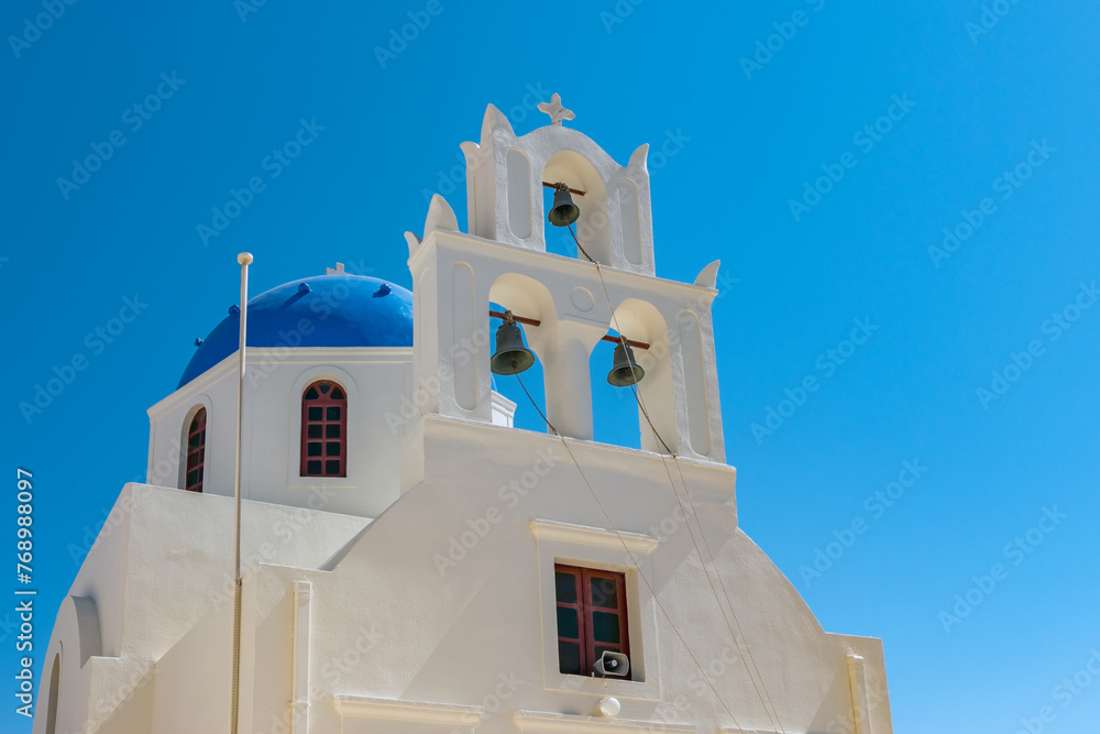 Old white greek church with blue dome on sky background on Santorini island. Greece.