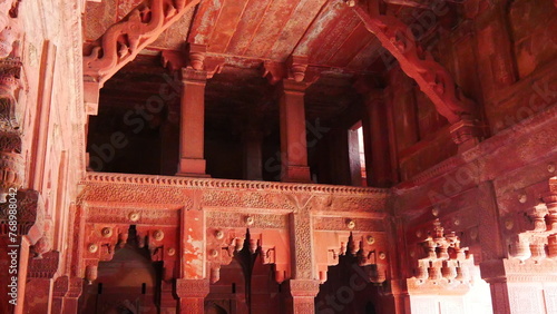 A l'intérieur et dans les couloirs du fort Rouge d'Agra, en Inde, avec ses murs et sa beauté architecturale, et courbé, avec des rayonnements du Soleil, quelques personnes, construction ancienne  photo