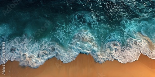 Aerial view of ocean meeting sandy beach with pristine blue waters and white foam © rorozoa