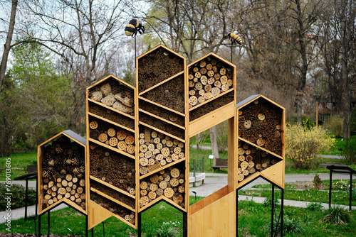 The handmade wooden bee hotel is located in the botanical garden in the center of Belgrade, the capital of Serbia. Holes for insects among cones and wood. Caring for ecology and environment concept. photo