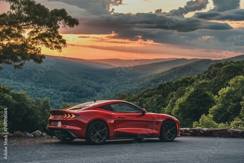 Luxury red sports car parked with a scenic mountain sunset backdrop