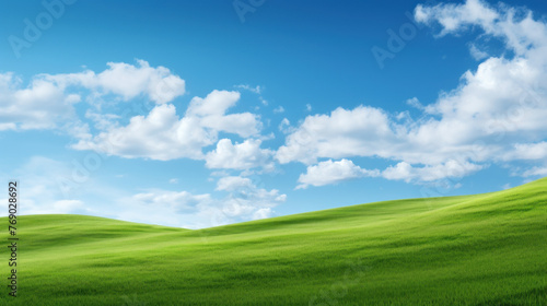 Beautiful Landscape view of green grass on a slope with blue sky and clouds background.