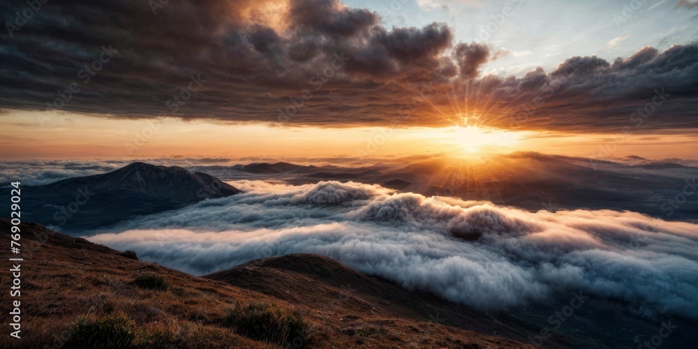   The sun sets behind the clouds atop a mountain, revealing a valley and distant mountains