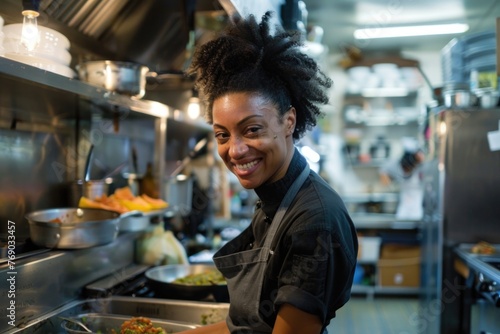African American female chef having fun while preparing food in the kitchen at restaurant