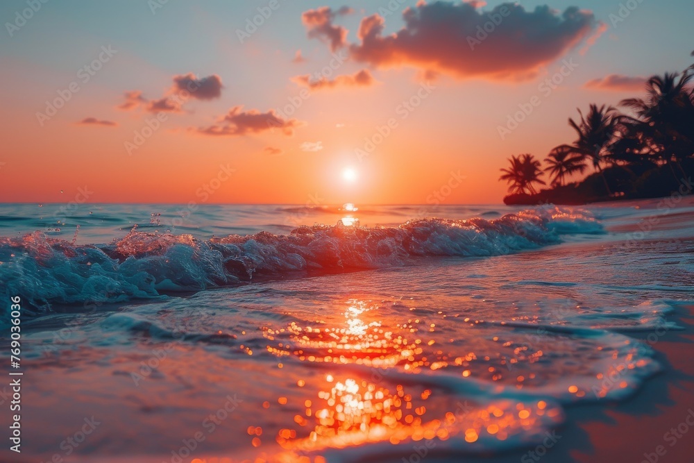 An intense orange sun sets over the sea, its light dancing on the waves of a beautiful tropical beach