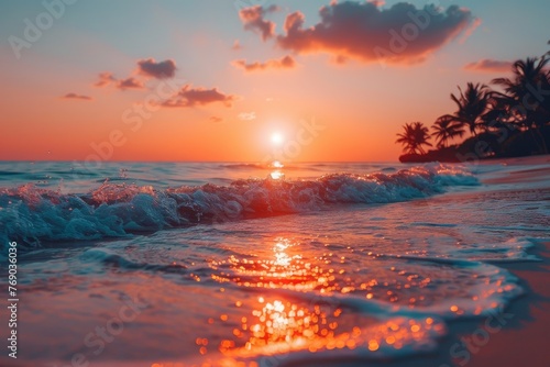 An intense orange sun sets over the sea, its light dancing on the waves of a beautiful tropical beach © LifeMedia