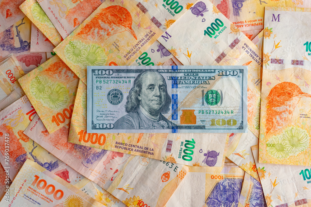 Billete de 100 dolares sobre billetes de 1000 pesos Billete de 100 dolares sobre billetes de 1000 pesos