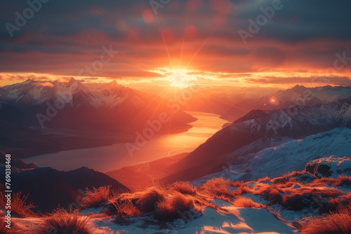 Orange sunlight illuminates the sky over a mountain lake at dusk