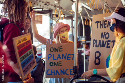 Activists with protest signs about climate change on a bus photo