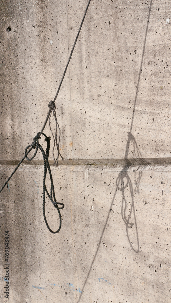 Cuerda de barco y sombra en pared de hormigón de puerto