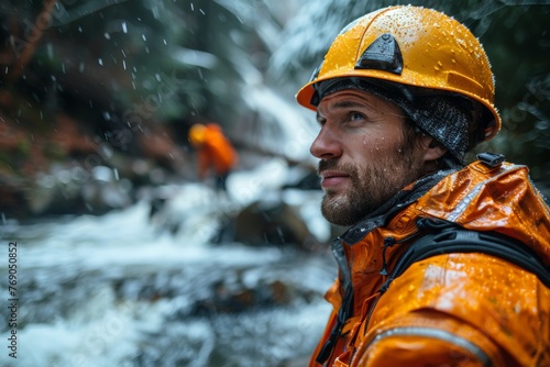 A forestry worker in orange safety gear is captured during work amidst heavy rain with visible water droplets