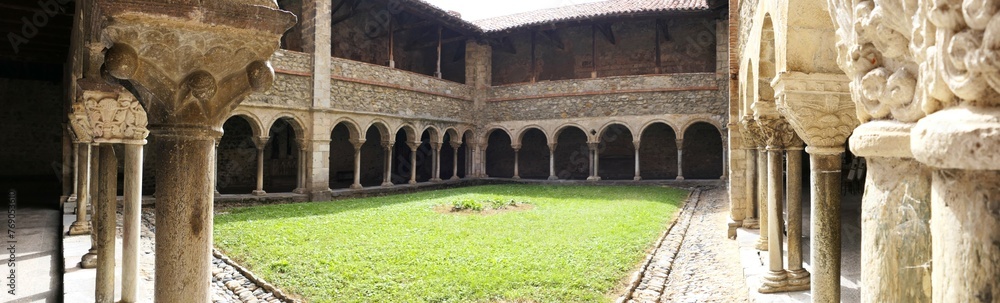 Fototapeta premium Panoramic view of the Romanesque cloister of the Saint-Lizier cathedral. XII century. Semicircular arches and pillars with beautiful capitals. Ariege. Occitanie. France