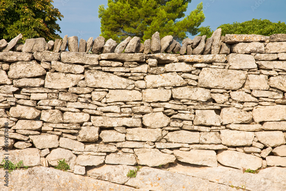 Typical old French dry wall built with stacked stones not fixed with mortar but simply overlapped and interlocked - (France - Provence)