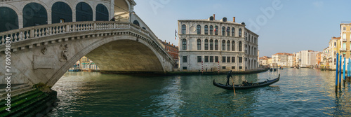 Panorama of the famous Rialto bridge with a gondola boat on the Canal Grande on a sunny winter day, Venice, Veneto, Italy