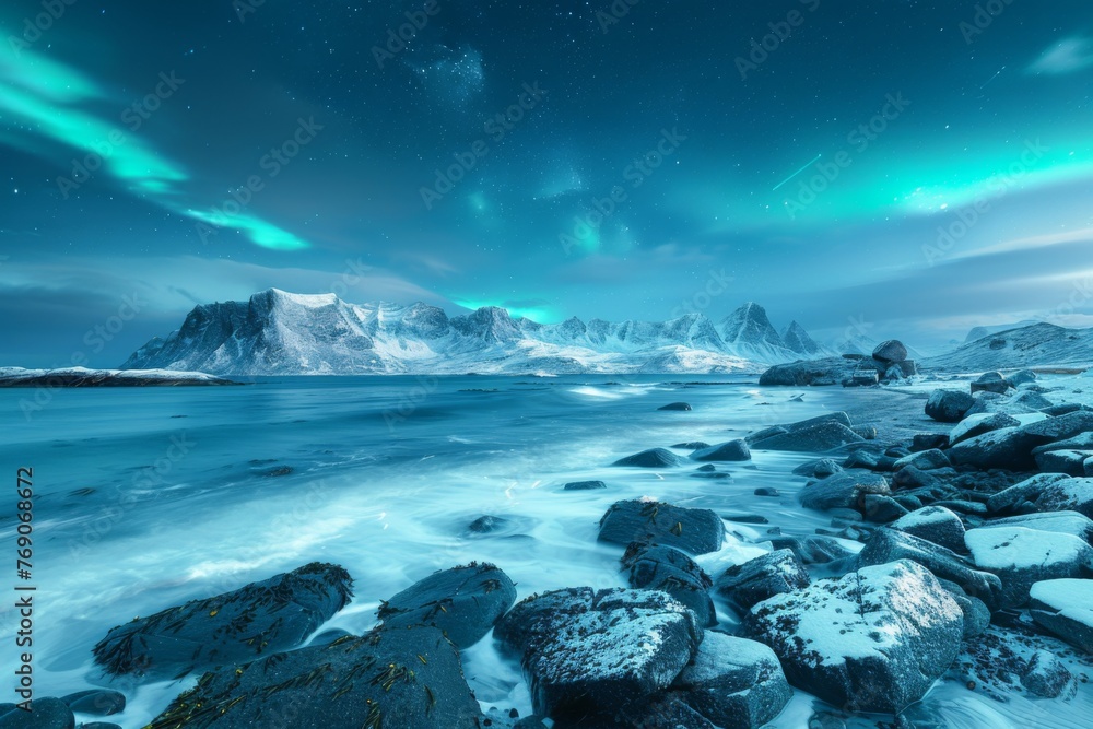 The aurora borealis illuminates the ocean and mountains under the night sky