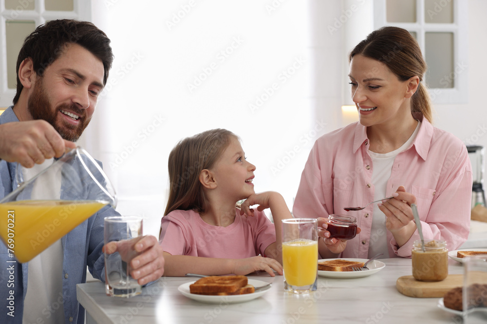 Happy family having breakfast at table in kitchen Happy family having breakfast at table in kitchen