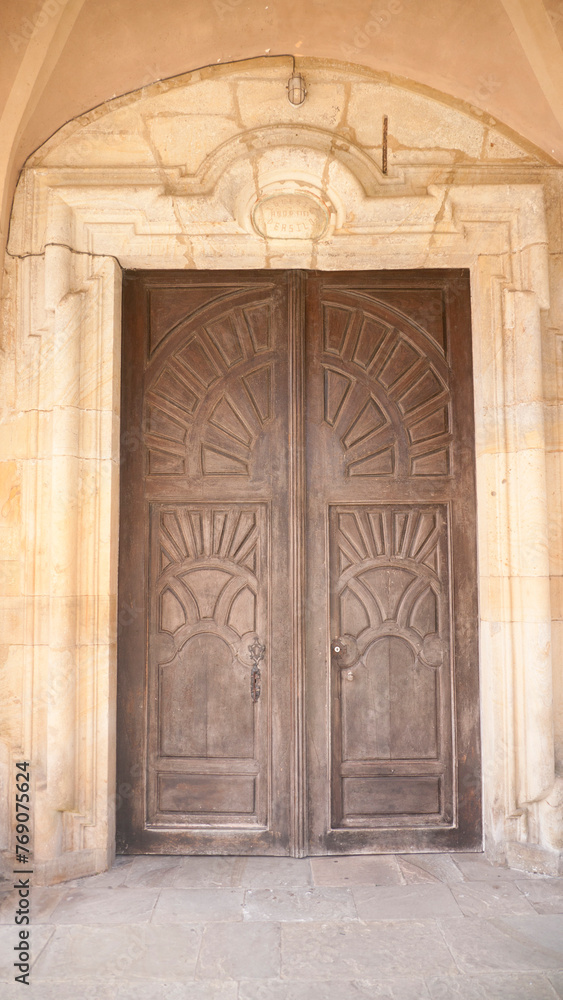 Puerta de madera tallada con formas gráficas en edificio antiguo