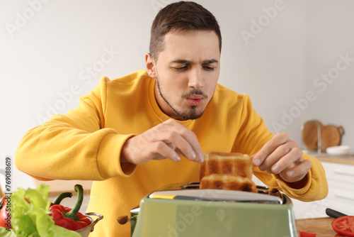 Young man taking hot toasts...