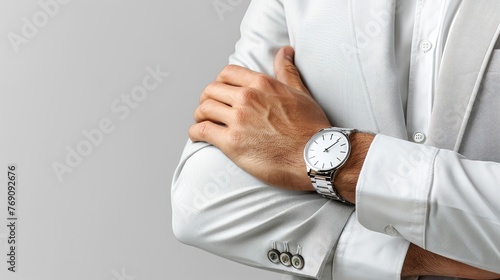 Close-up of a man's arm crossing with a watch, against a light backdrop. photo