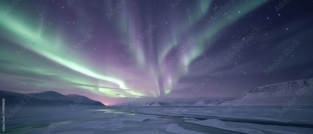 The northern lights streak across the sky, offering a luminous backdrop to a snow-covered road winding through the Arctic expanse.