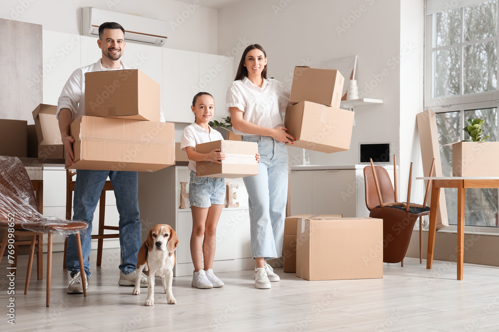 Happy family with boxes and Beagle dog in kitchen on moving day Happy family with boxes and Beagle dog in kitchen on moving day