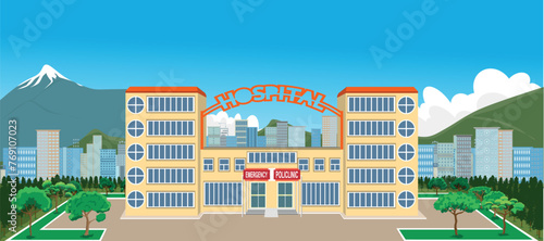 Hospital building with snowy mountains and city behind it