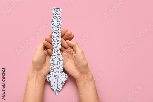 Woman with paper spine on pink background