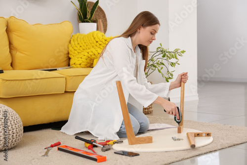 Young woman assembling flat...