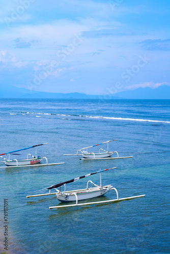 Traditional local colored fisherman's catamaran boats on the ocean shore on an island in Indonesia.