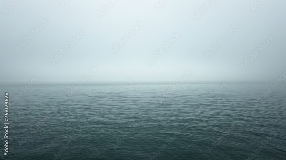 A foggy day, with a solitary boat floating on a vast expanse of water A foggy day, with a solitary boat floating on a vast expanse of water