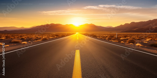 A road in the desert with mountains in the background at sunset
