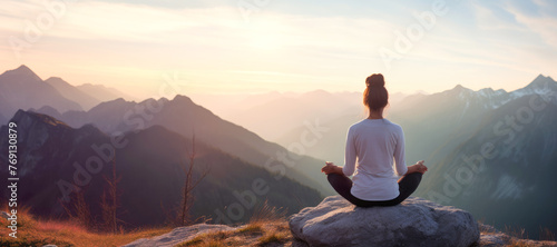 Embracing the serenity of nature, a silhouette of a person meditating on a mountain peak. photo