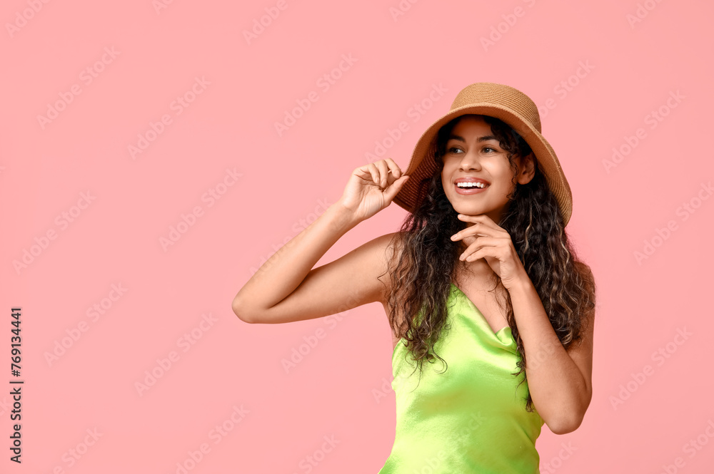 Stylish African-American woman in dress and hat on pink background Stylish African-American woman in dress and hat on pink background