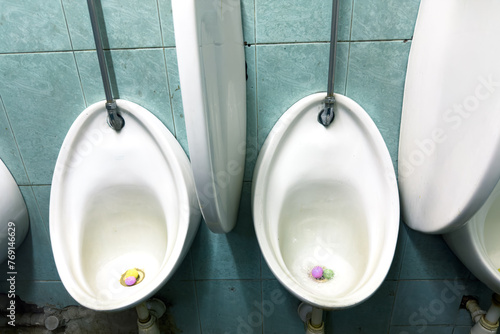 A set of dirty urinal basin in a washroom indoors 