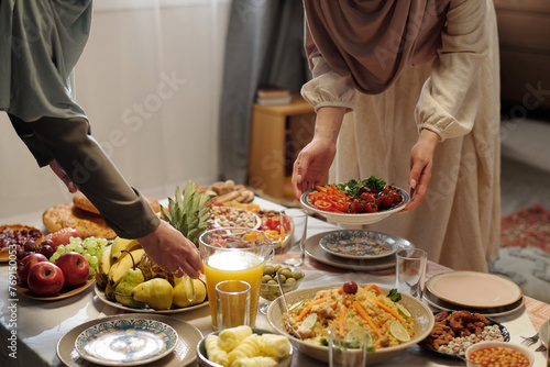 Unrecognizable Muslim Women Setting Festive Table