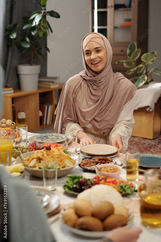 Cheerful Muslim Woman Sitting At Festive Table Cheerful Muslim Woman Sitting At Festive Table