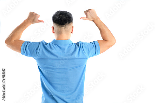 oriental man with blue polo shirt on his back with thumbs pointing at his back on white background