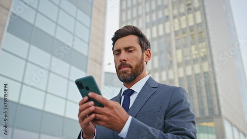 Financial manager browsing app looking smartphone screen on street close up. 