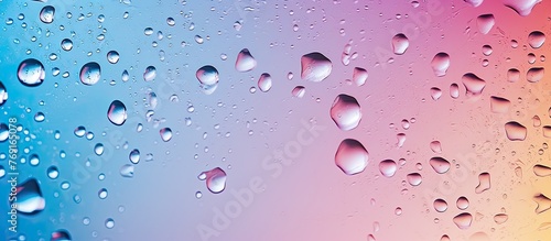 Close-up view of tiny water droplets clinging to a glass window  set against a vibrant rainbow in the background