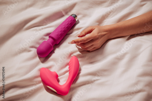 Canvastavla sex vibrator and vacuum stimulator in a woman girl hand on a white sheet on the bed in bedroom
