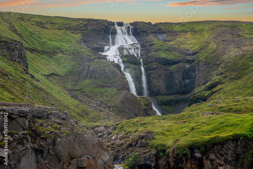 Bjarnarfoss waterfall flowing from a high hill photo