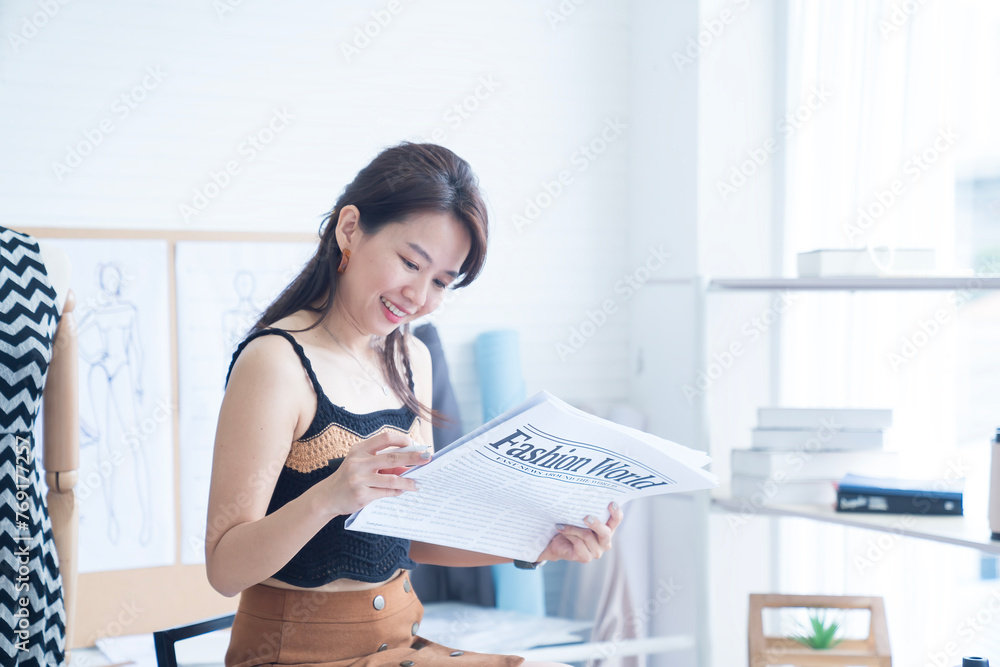 Designer reading newspaper about fashion. Women fashion designer stylist working. Designer reading newspaper about fashion. Women fashion designer stylist working.