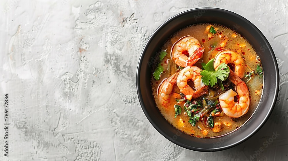tom yum kung Spicy Thai soup with shrimp in a black bowl on a dark stone background tom yum kung Spicy Thai soup with shrimp in a black bowl on a dark stone background