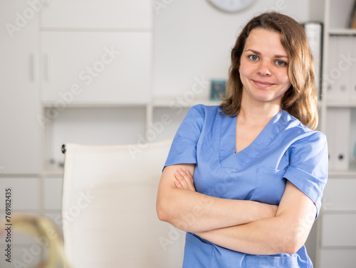 Portrait of female doctor who is working and posing on her workplace in the clinic. © JackF