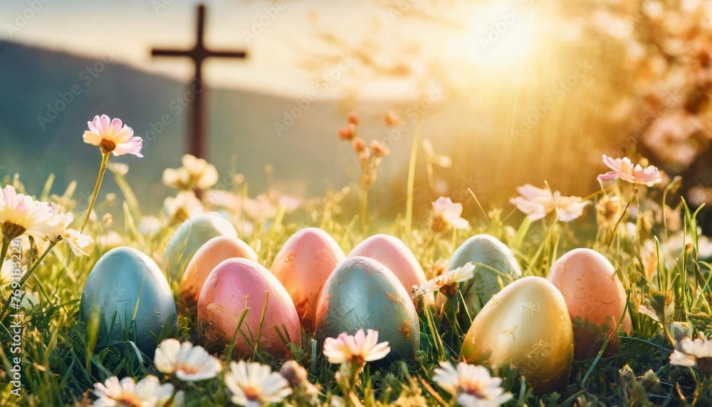 easter background with colorful painted easter eggs in the grass with spring flowers and a cross in the background easter resurrection religious background with copy space for text - obrazy, fototapety, plakaty 