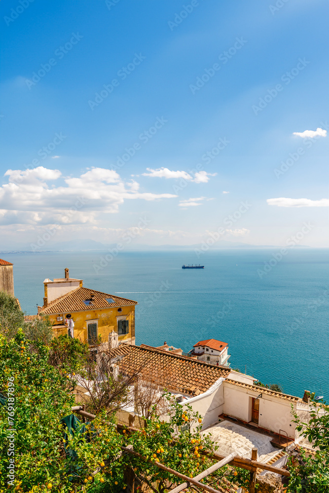 Italian landscape. Old houses with tiled roofs on a background of blue sea and sky