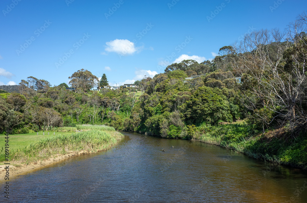 Wye River Landscape: Serene Waterway with Lush Australian natural Vegetation and some holiday houses in the distance. Wye River is a small regional and coastal town on Great Ocean Road.