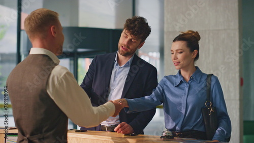 Travelers couple check hotel on holiday trip. Beautiful woman paying contactless photo