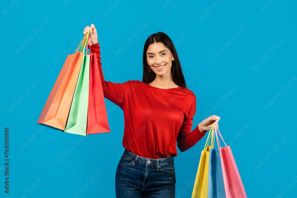 Woman in Red Shirt Holding Shopping Bags And Smiling