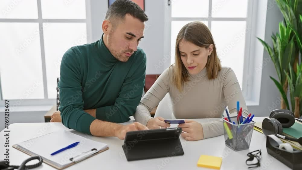 Man and woman review documents on tablet in modern office, displaying teamwork and professionalism in a corporate setting. Man and woman review documents on tablet in modern office, displaying teamwork and professionalism in a corporate setting.